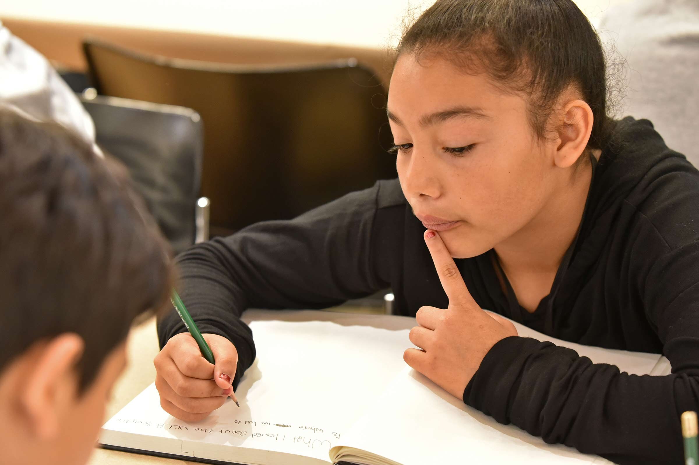 Child writing in a notebook.