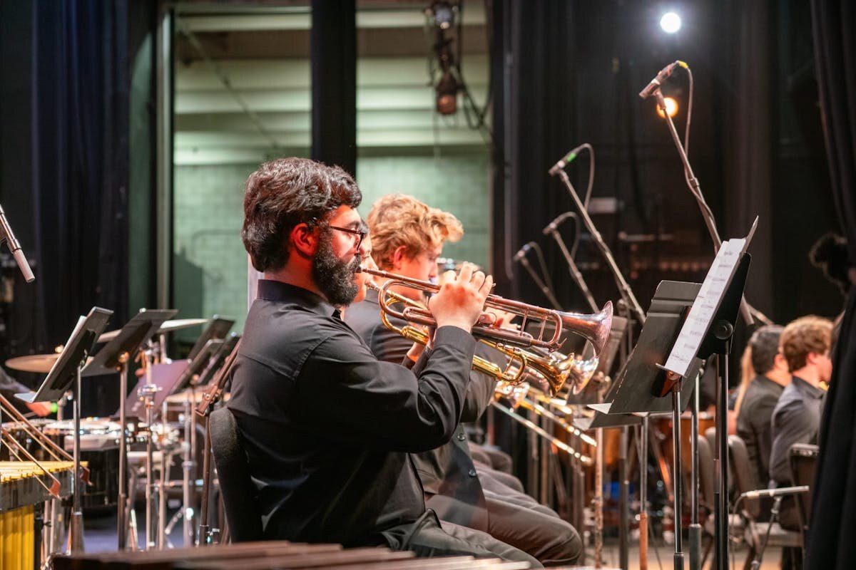 Trumpet players performing with a large ensemble
