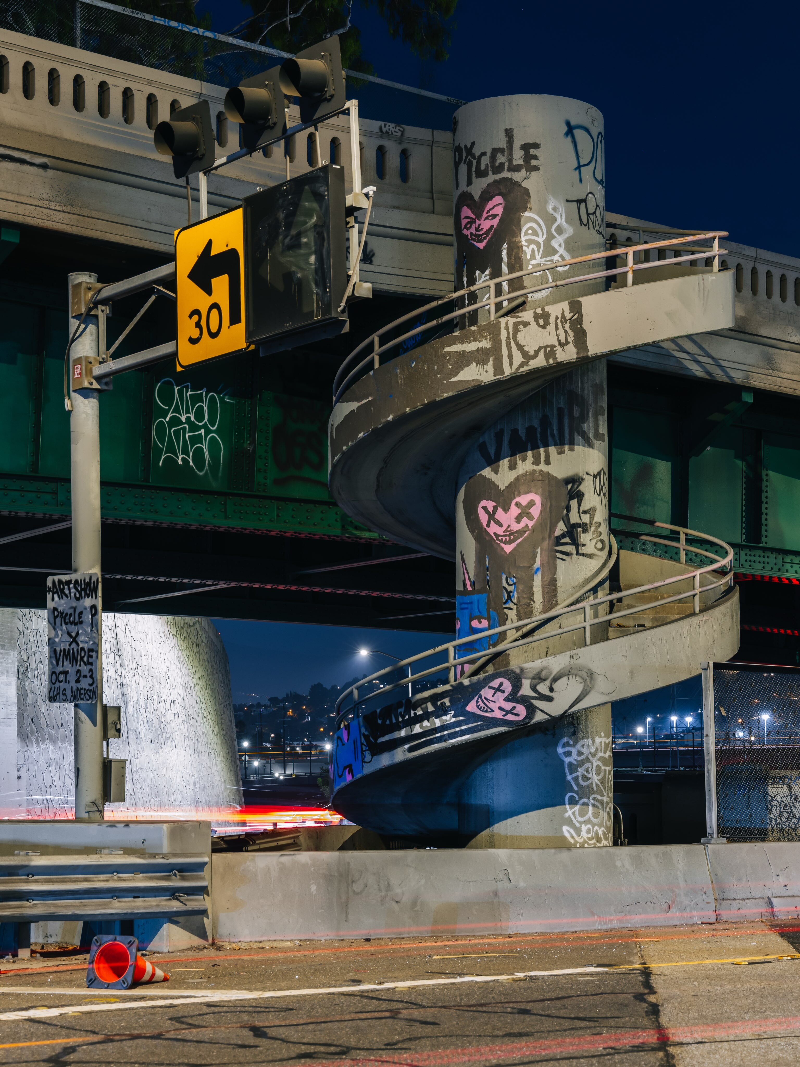 Piccle P and VMNRE street-art characters painted on a Los Angeles freeway structure.