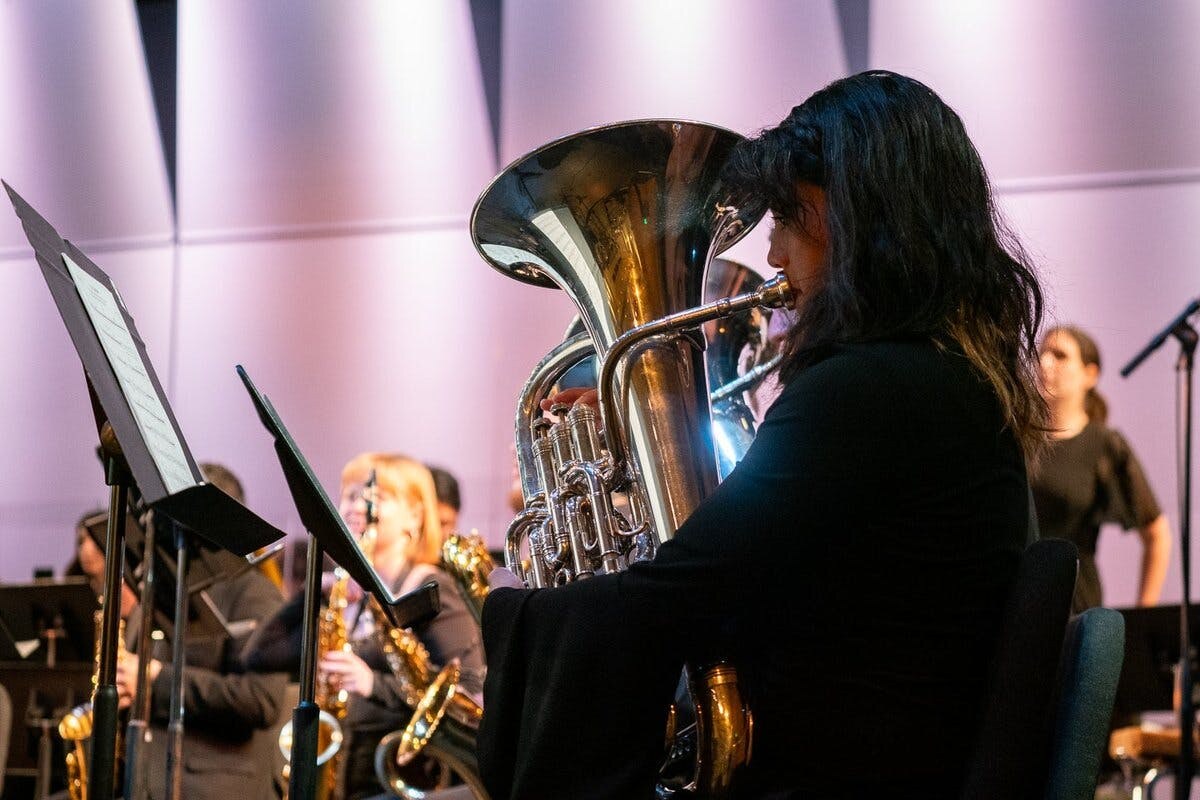 Closeup of tuba performer among an orchestra onstage