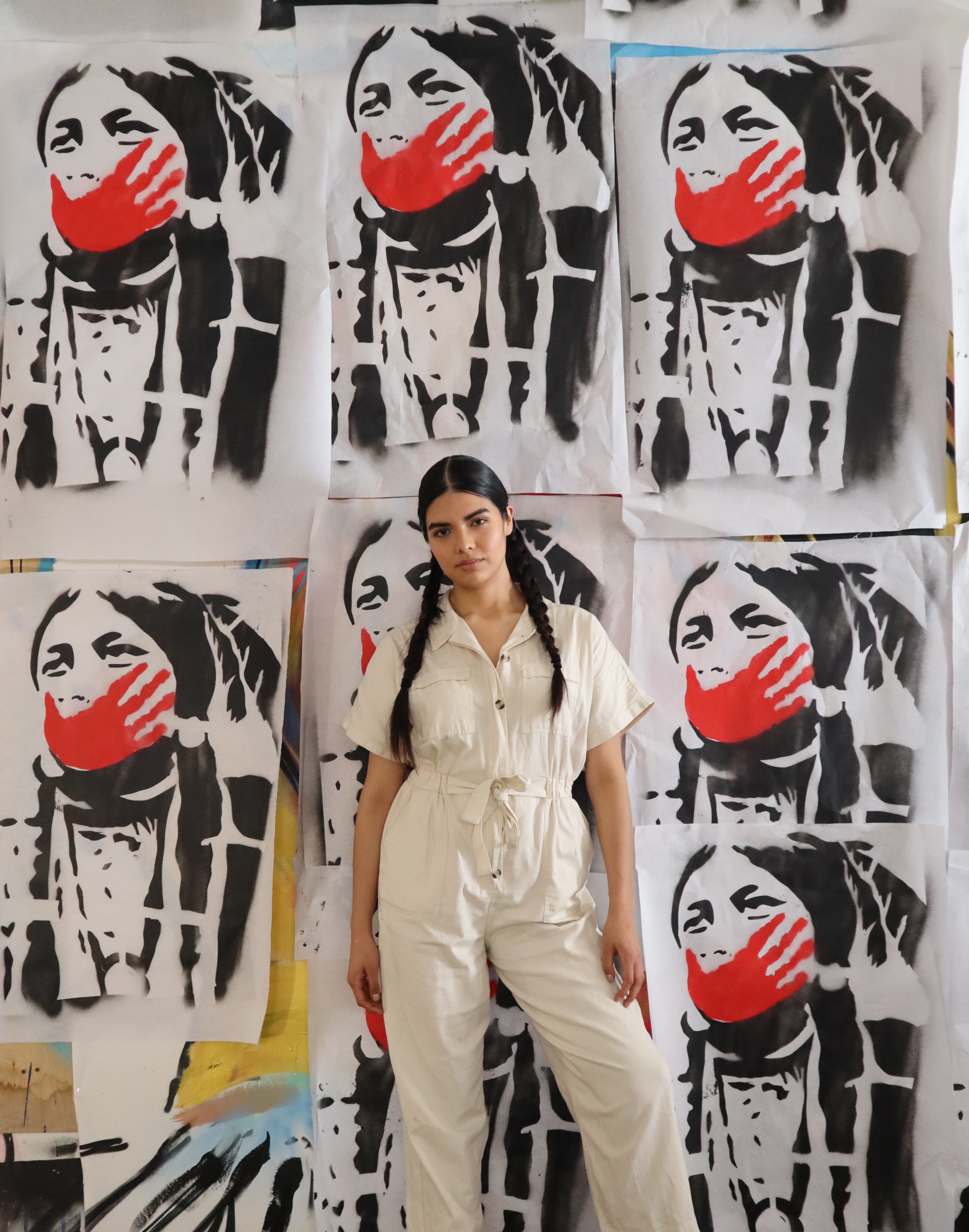 Artist Siyowin photographed in front of protest-inspired artwork for an Autry creative workshop