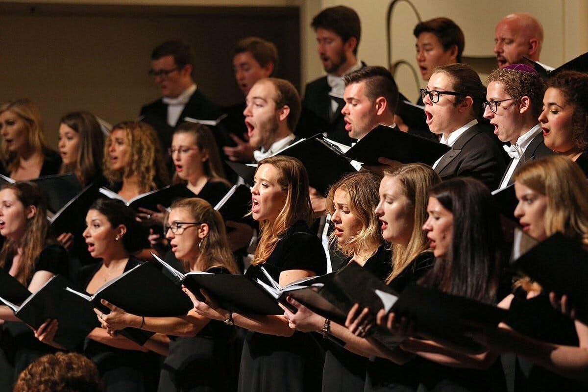 A group of singers holding black choir books