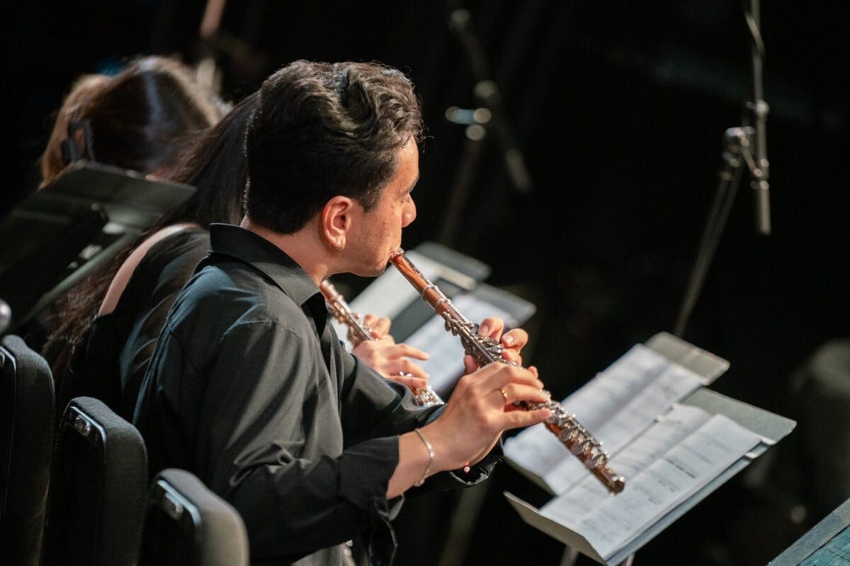 Closeup of a flutist performing with an orchestra