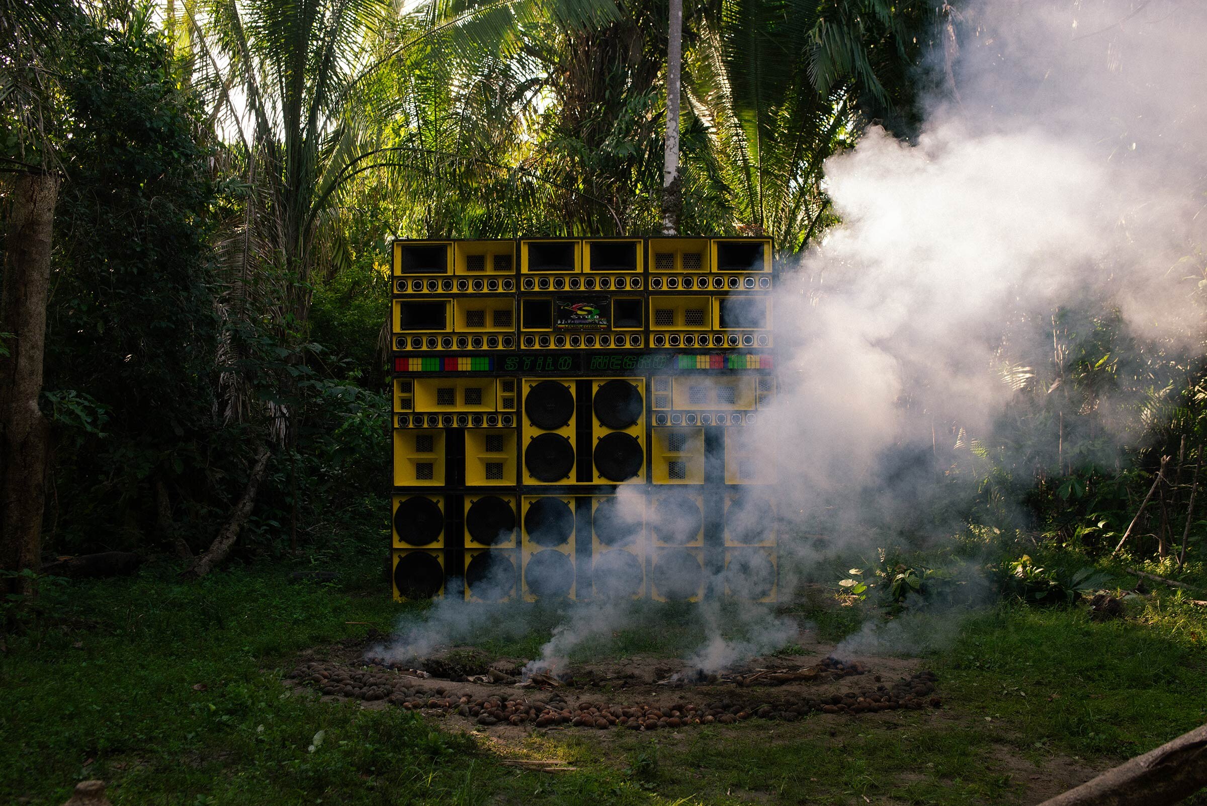 A wall of yellow speakers, surrounded by smoke